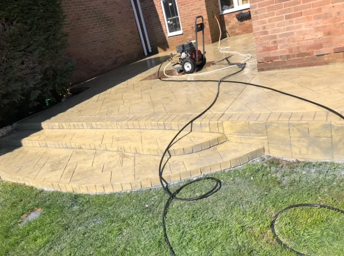 Patterned imprinted concrete driveway installation in Wrexham with curved border